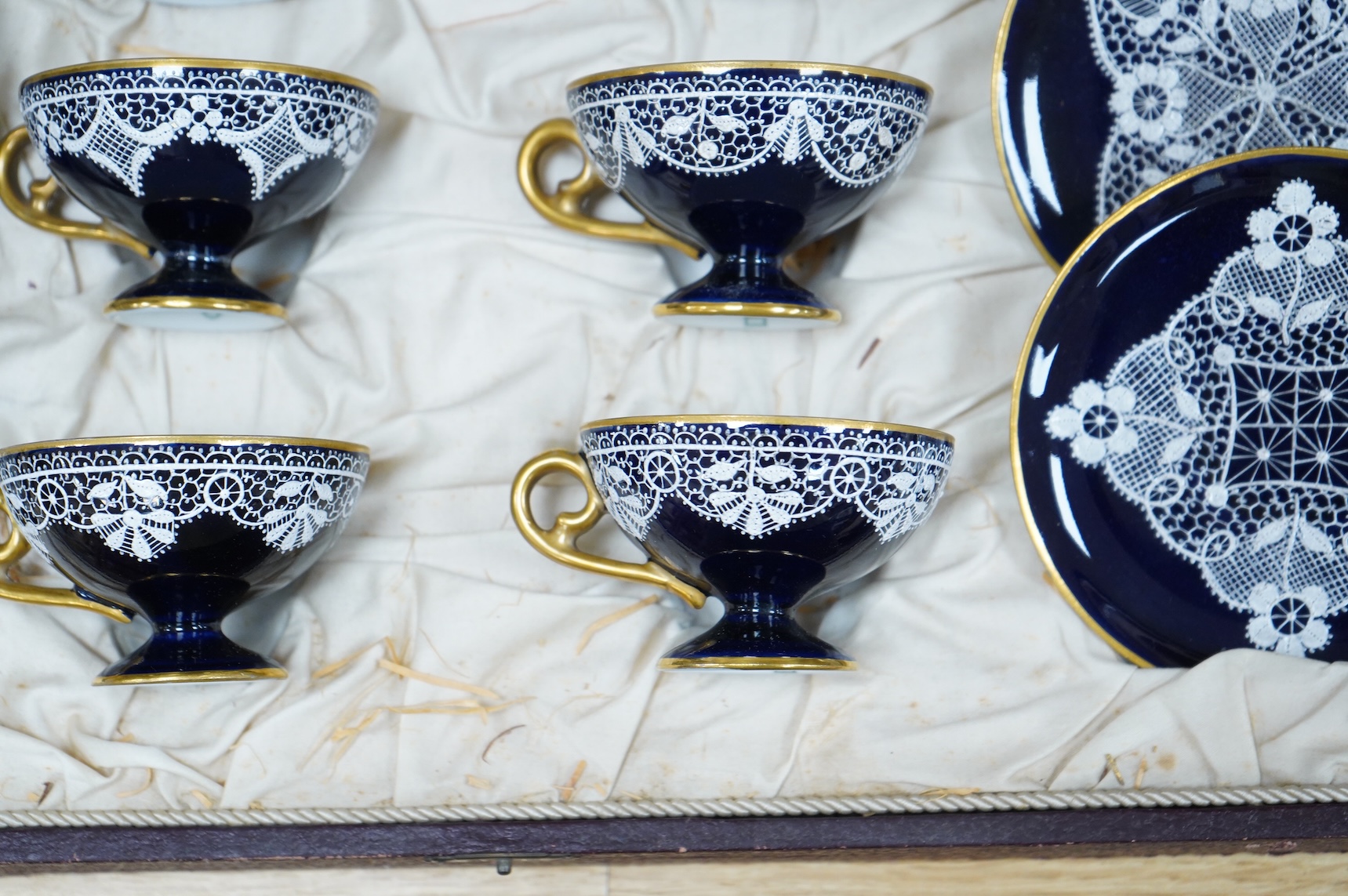 A Vienna-style lace-pattern coffee set, Beehive marks, cased